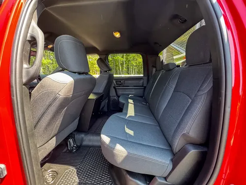 Rear floor and center-console base close-up with power outlet and panel controls.
